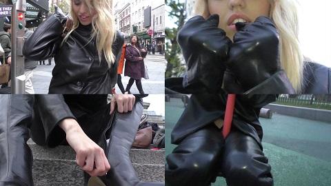 girl in leather gloves and leather pants making a fist gesture